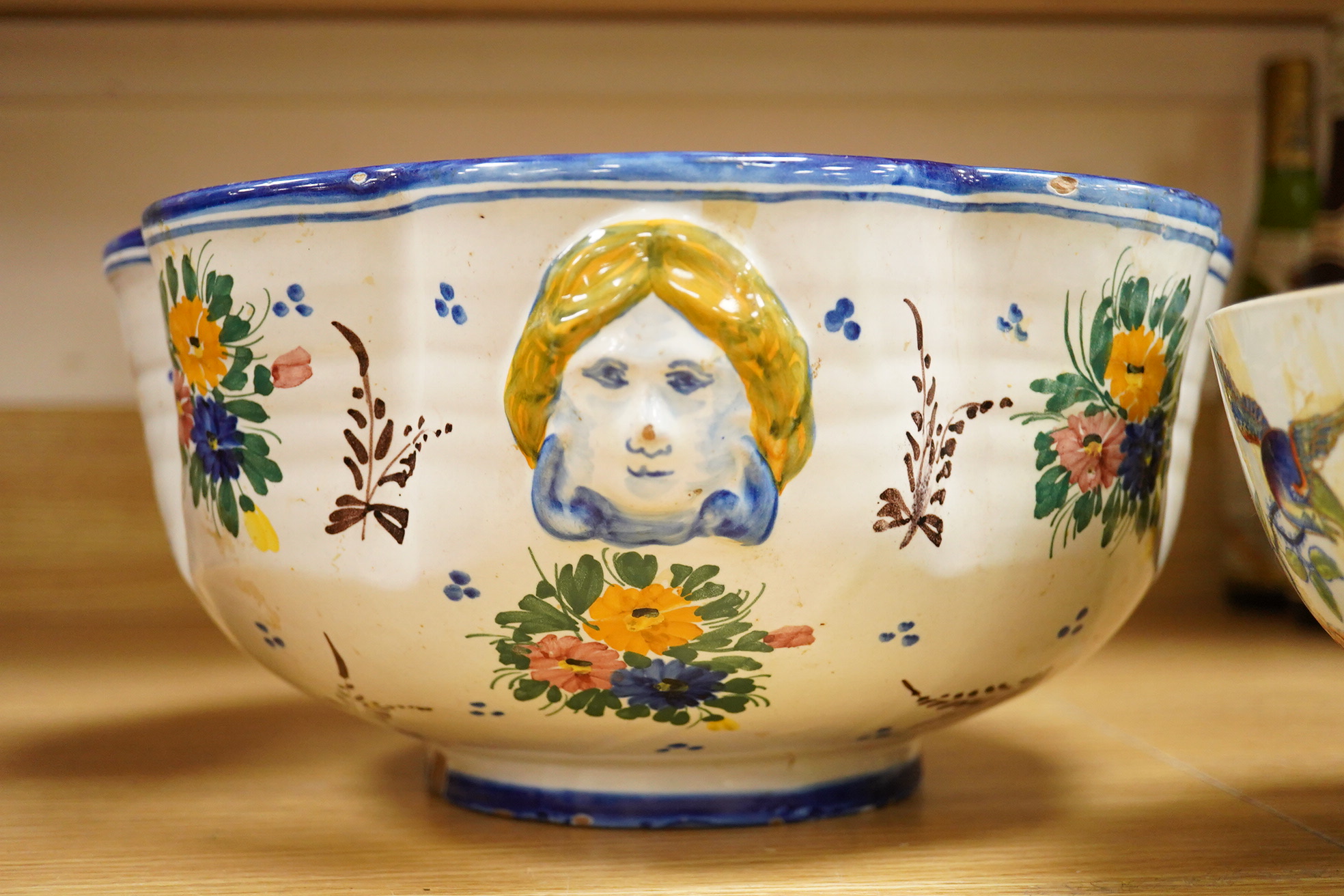 An Italian faience punch bowl painted with flowers and masks and an ironstone pedestal bowl, largest 31cm in diameter